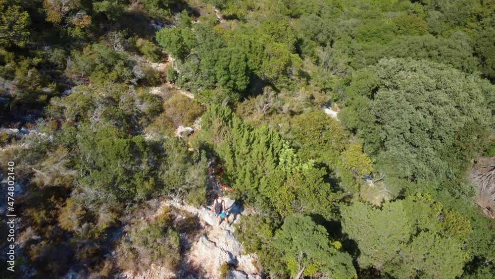 Hiker walking on a path in the middle of mediterranean vegetation of Kefalonia island in Greece Hiker walking on a path in the middle of mediterranean vegetation of Kefalonia island in Greece