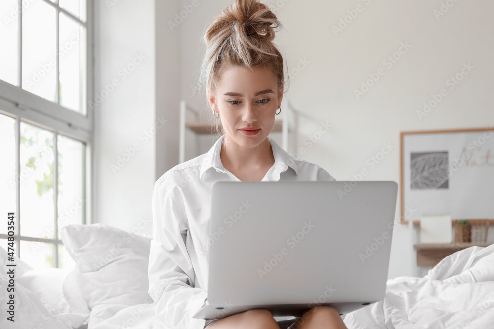 Morning of beautiful young woman using laptop on bed Morning of beautiful young woman using laptop on bed