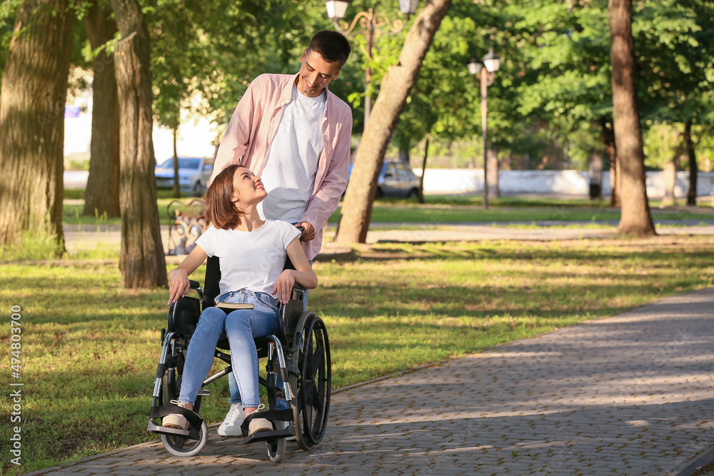 Young woman with physical disability and her husband in park Young woman with physical disability and her husband in park