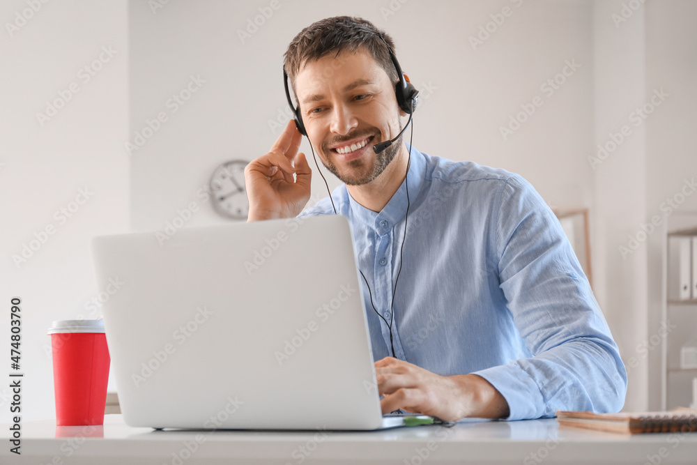 Consultant of call center working with laptop at table in office Consultant of call center working with laptop at table in office