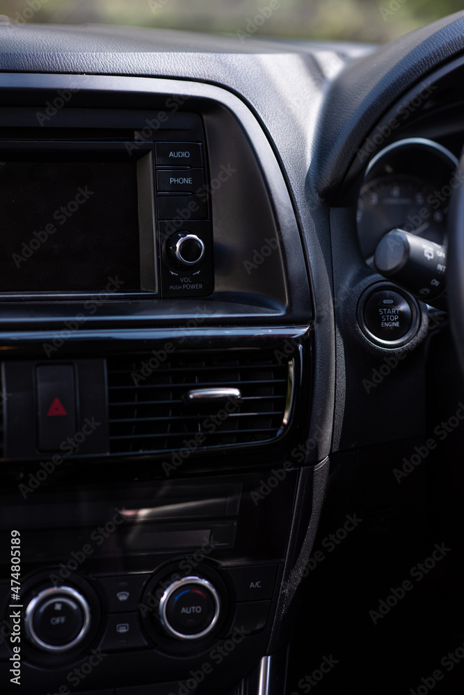 Buttons for audio, phone and sound volume on the dash board of a Japanese SUV car. Seeing an air grill for a ventilation.