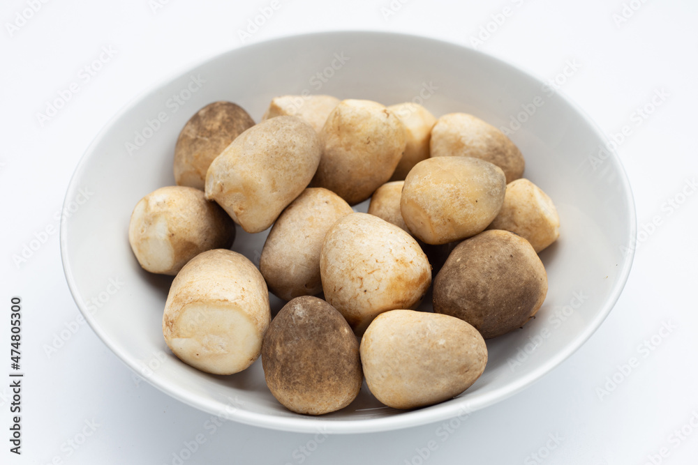 Straw mushroom in white bowl on white background. Straw mushroom in white bowl on white background.