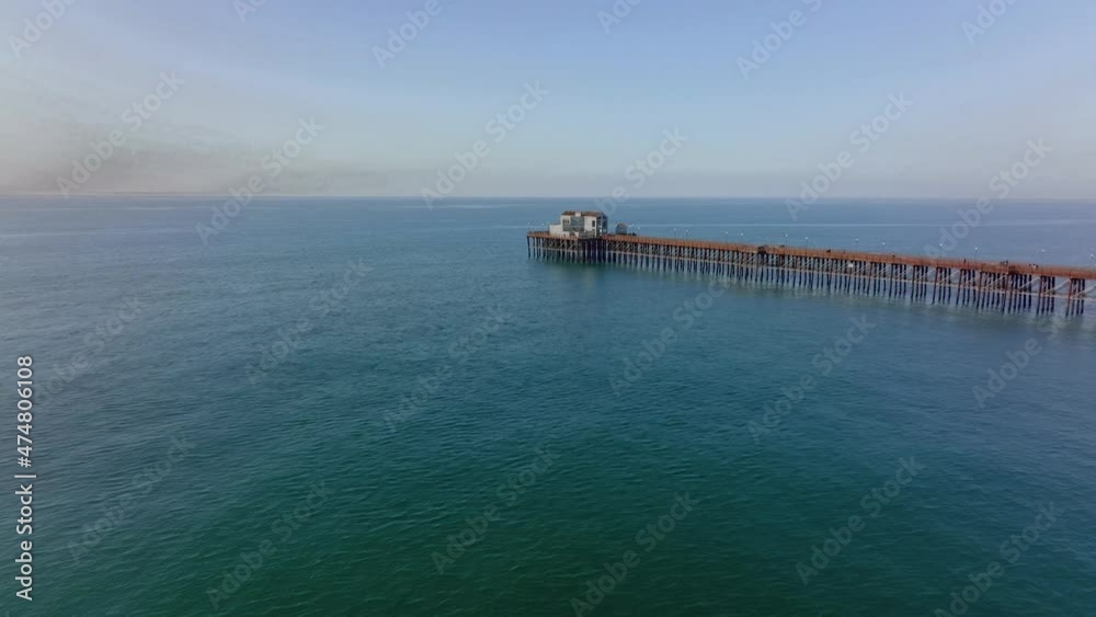 drone forwards over ocean water toward wooden pier in Oceanside, south California, United States drone forwards over ocean water toward wooden pier in Oceanside, south California, United States
