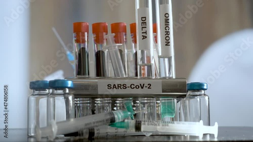 Laboratory SARS COV 2 Test Tubes Labelled Alpha Gamma Delta Beta And Omicron Variants Being Placed Into Rack. Locked Off, Establishing Shot photo