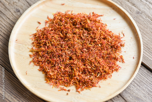 Canvas-taulu Dried safflower for herbal tea on tray wooden background, dry safflower petals,