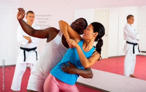 Asian woman training to fight off a man attack in self defense lesson