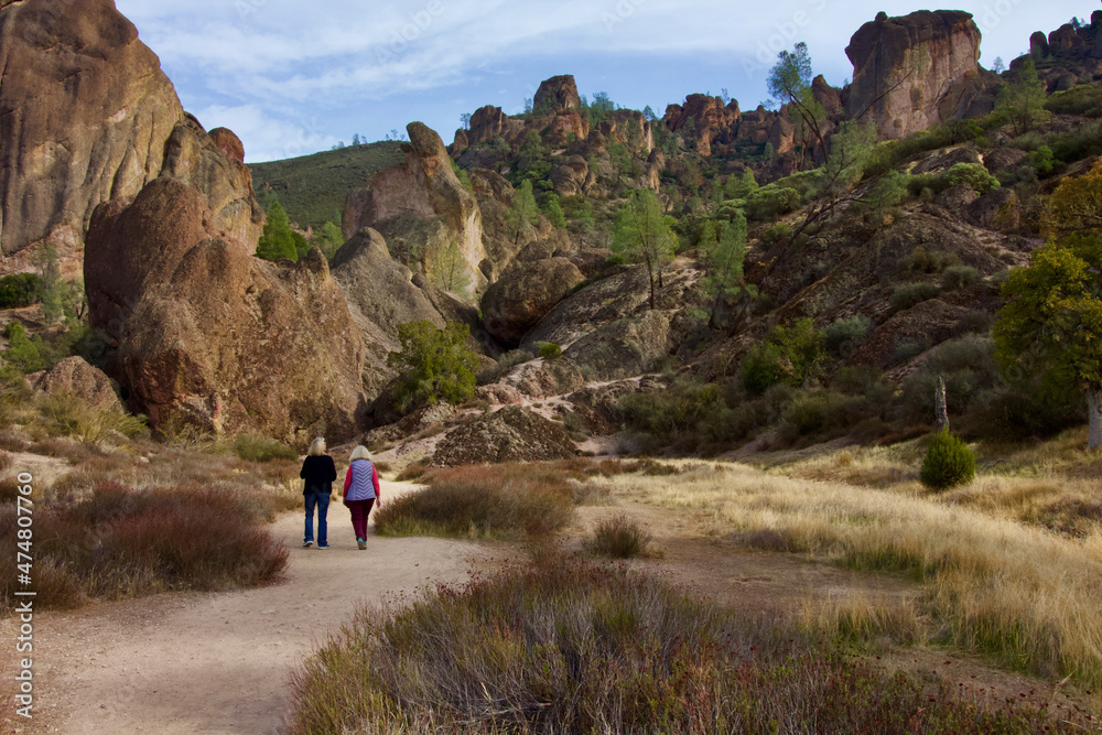 2 senior women walk together on a pathway in pinnacles national park, Monterey county, california, u.s.a. 2 senior women walk together on a pathway in pinnacles national park, Monterey county, california, u.s.a.
