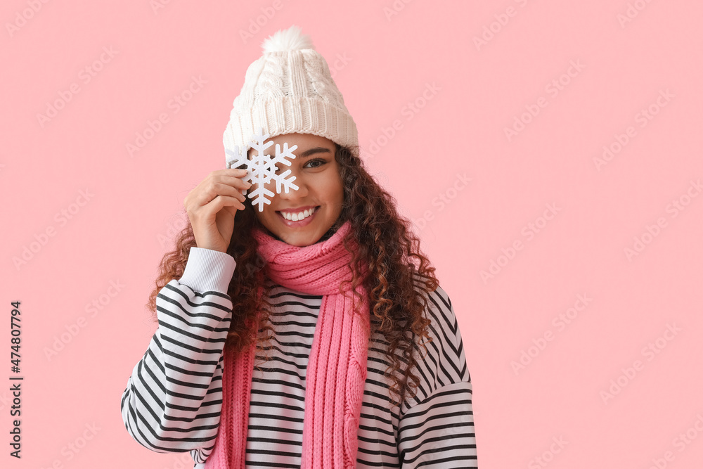 Beautiful young African-American woman with snowflake on color background Beautiful young African-American woman with snowflake on color background