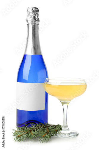 Glass and bottle of champagne with fir branch on white background