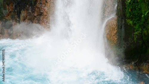 Close-up footage of the massive amounts of water crashing down in a beautiful turquoise pool. Rio Celeste waterfall in Alajuela, Costa Rica during green season. Tourism concepts in full HD. photo