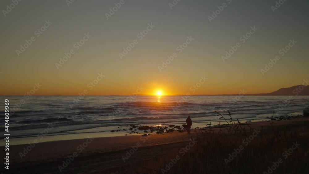 Quiet beach with silhouette of man walking by Quiet beach with silhouette of man walking by