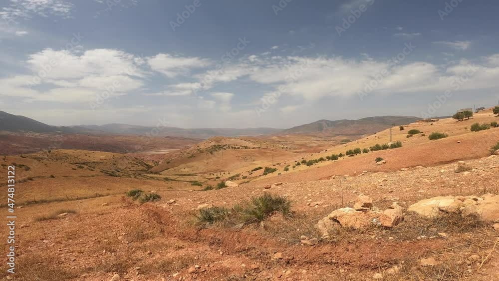 Video of a barren rocky mountain range with a few houses and scanty vegetation on a beautiful sunny day with a few white clouds. Video of a barren rocky mountain range with a few houses and scanty vegetation on a beautiful sunny day with a few white clouds.