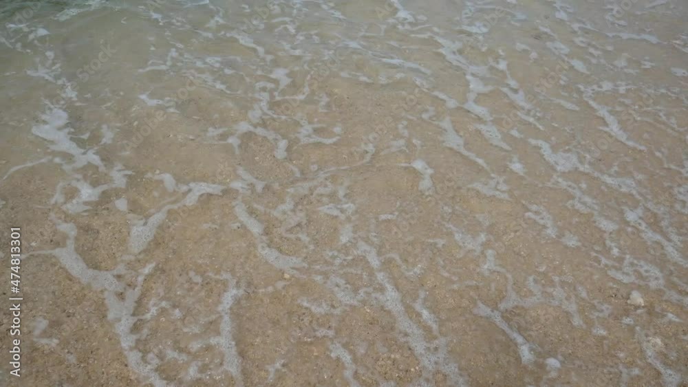 Omicron lettering on beach white sand erased by waves Omicron lettering on beach white sand erased by waves