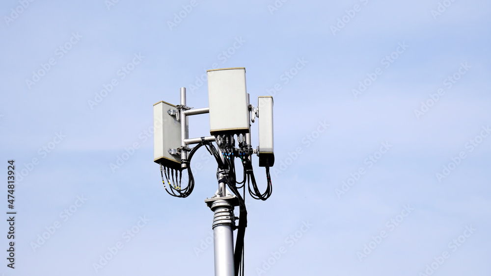 Telecommunication pole of 4G and 5G cellular. Macro Base Station. 5G radio network telecommunication equipment with radio modules and smart antennas mounted on a metal against blue sky background. Telecommunication pole of 4G and 5G cellular. Macro Base Station. 5G radio network telecommunication equipment with radio modules and smart antennas mounted on a metal against blue sky background.