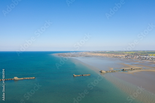 The artificial port of Gold beach in Asnelles on the sandy beach in Europe, France, Normandy, Arromanches les Bains, in summer on a sunny day.