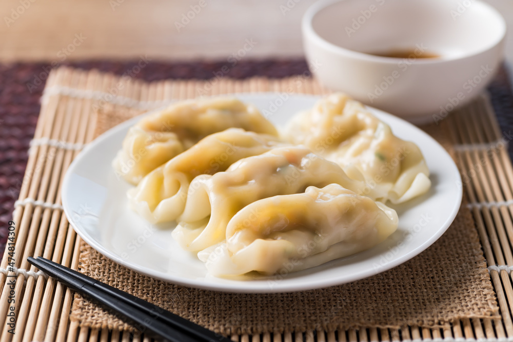 Steamed wonton dumpling stuffed with minced pork on plate eating with sesame oil sauce, Asian food Steamed wonton dumpling stuffed with minced pork on plate eating with sesame oil sauce, Asian food