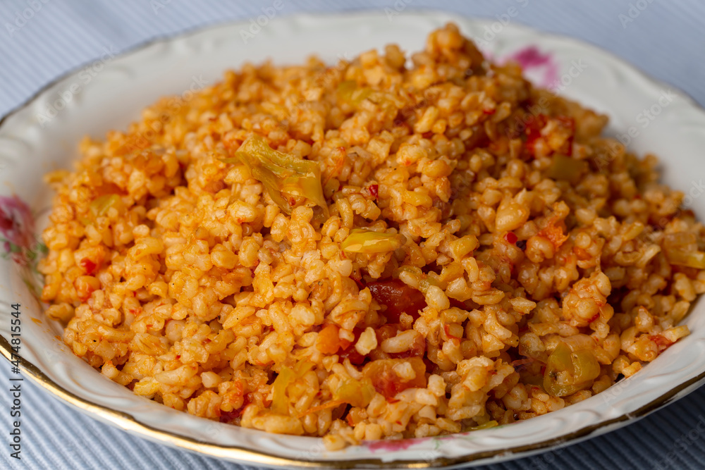 Traditional turkish bulgur pilaf with tomato sause in plate (Turkish name; meyhane pilavi) Traditional turkish bulgur pilaf with tomato sause in plate (Turkish name; meyhane pilavi)