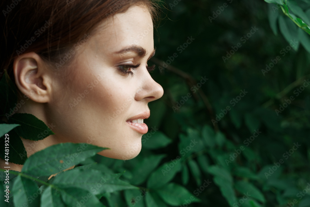 smiling woman Cosmetology nature green leaves glamor close-up smiling woman Cosmetology nature green leaves glamor close-up