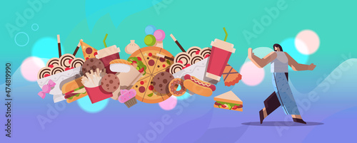 woman showing no stop gesture to junk food assortment of fast food unhealthy nutrition junkfood addiction concept