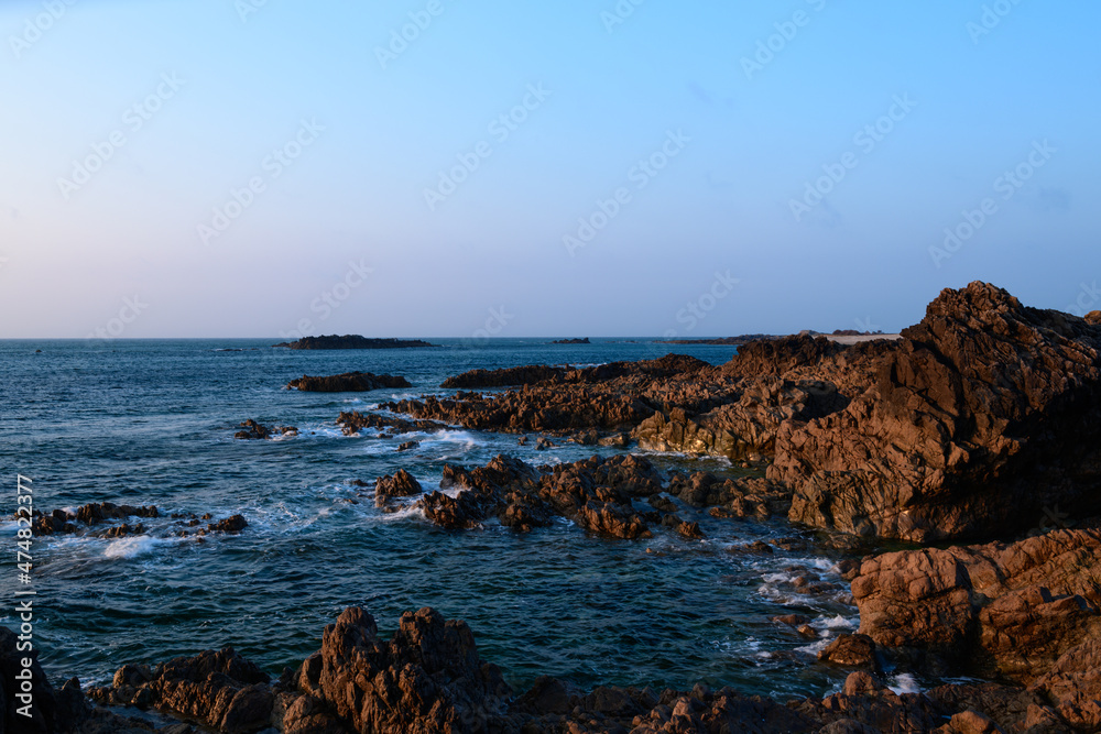 The rocks of the Cap de la Hague lighthouse in Europe, France, Normandy, Manche, in spring, on a sunny day.