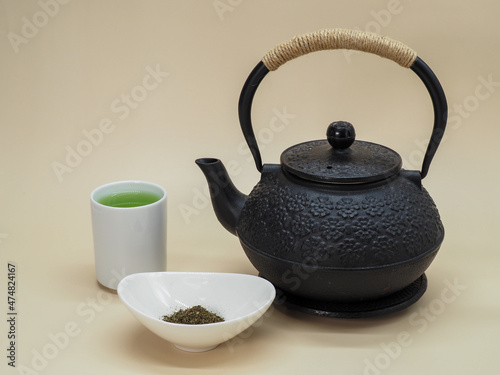 Cup of Fresh Green Tea with Black Cast Iron Teapot