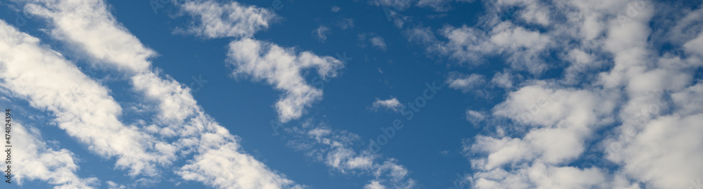 Dramatic cloudscape with fast moving white clouds against a blue sky, as a nature background
