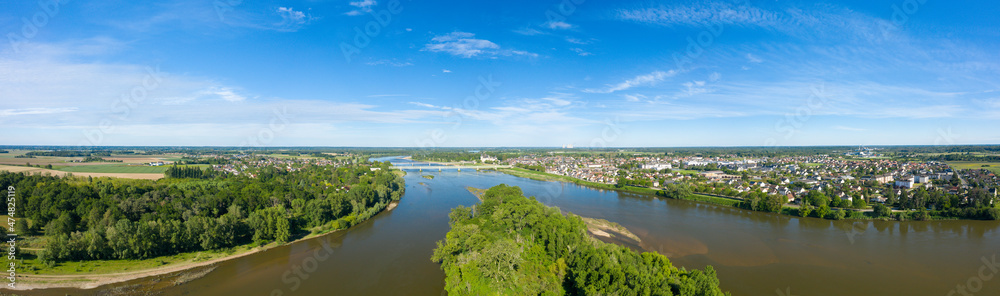 The panoramic view of the city of Sully sur Loire and its river in Europe, in France, in the Center region, in the Loiret, in summer, on a sunny day.