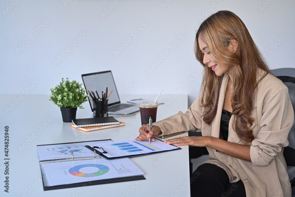 Side view smiling businesswoman working in modern workplace. Side view smiling businesswoman working in modern workplace.