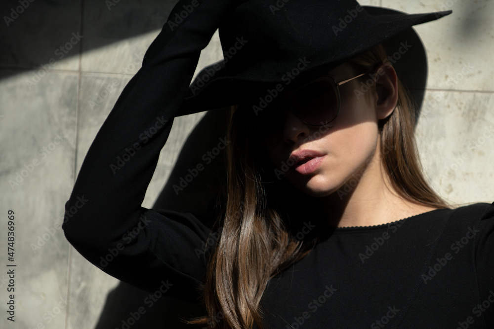 Street style photo of elegant fashionable woman wearing trendy clothes. Model in hat walking in street of European city. Mafia woman. Street style photo of elegant fashionable woman wearing trendy clothes. Model in hat walking in street of European city. Mafia woman.