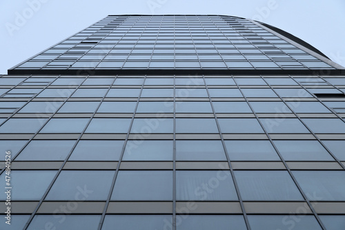 Bottom view of the wall of a high-rise glazed building.