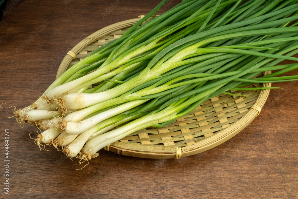Fresh spring onion in bamboo basket on wooden background. Fresh spring onion in bamboo basket on wooden background.