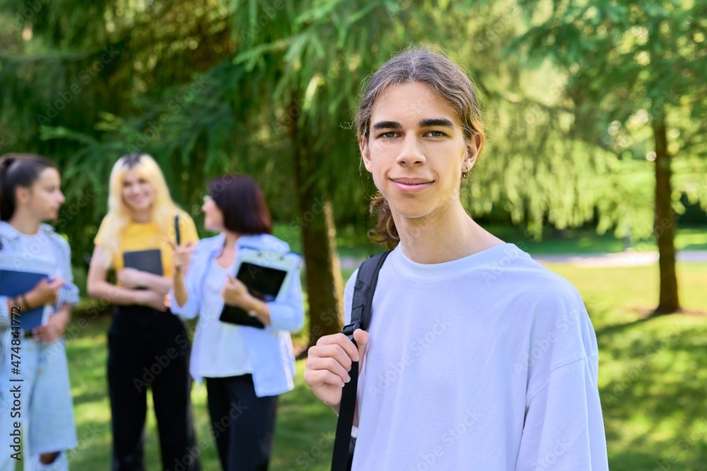 Male student 16, 17 years old with backpack, in school park Male student 16, 17 years old with backpack, in school park