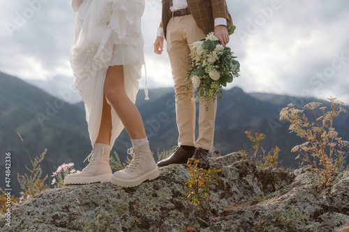 Legs of the bride and groom in wedding dresses