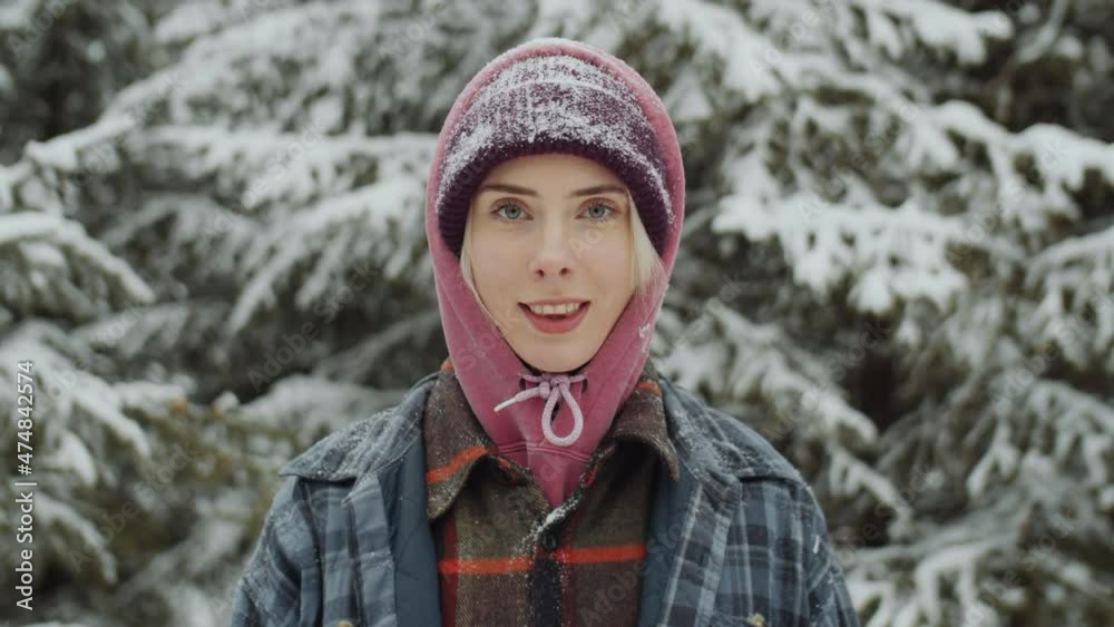 Portrait of young beautiful woman standing in forest on winter day and posing for camera Portrait of young beautiful woman standing in forest on winter day and posing for camera