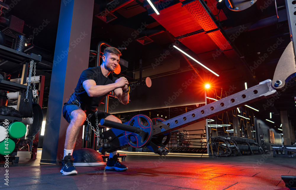Obraz premium Athletic doing exercises in modern gym. Handsome strong man training in the gym.