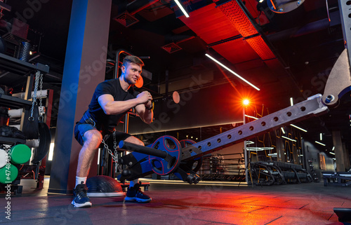 Athletic doing exercises in modern gym. Handsome strong man training in the gym.