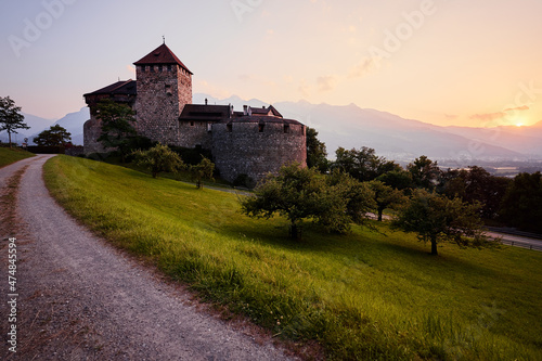 Vaduz Castle, the official residence of the Prince of Liechtenstein, with Alps mountains in background on sunset.