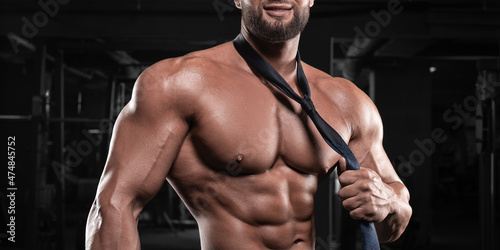Photos Attractive man with a pumped-up body posing in the gym
