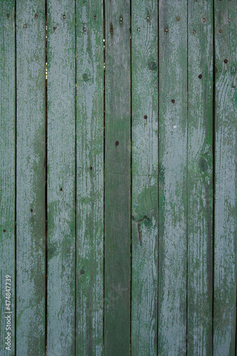 texture of a wooden fence. fence painted green. peeling paint on an old fence. old wood texture. photo can be used as a photophone, as a texture