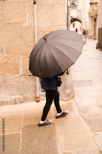 Mujer resguardada de la lluvia tras un paraguas