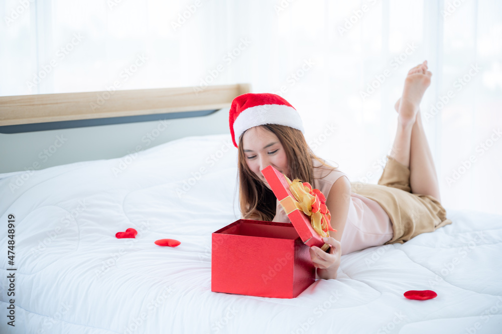 Fototapeta premium Christmas gift box concept, young Asian woman are happy and smile with a surprise gift present