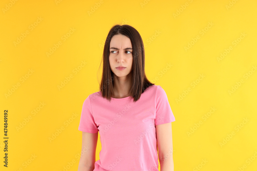 Young attractive woman in t-shirt on yellow background Young attractive woman in t-shirt on yellow background