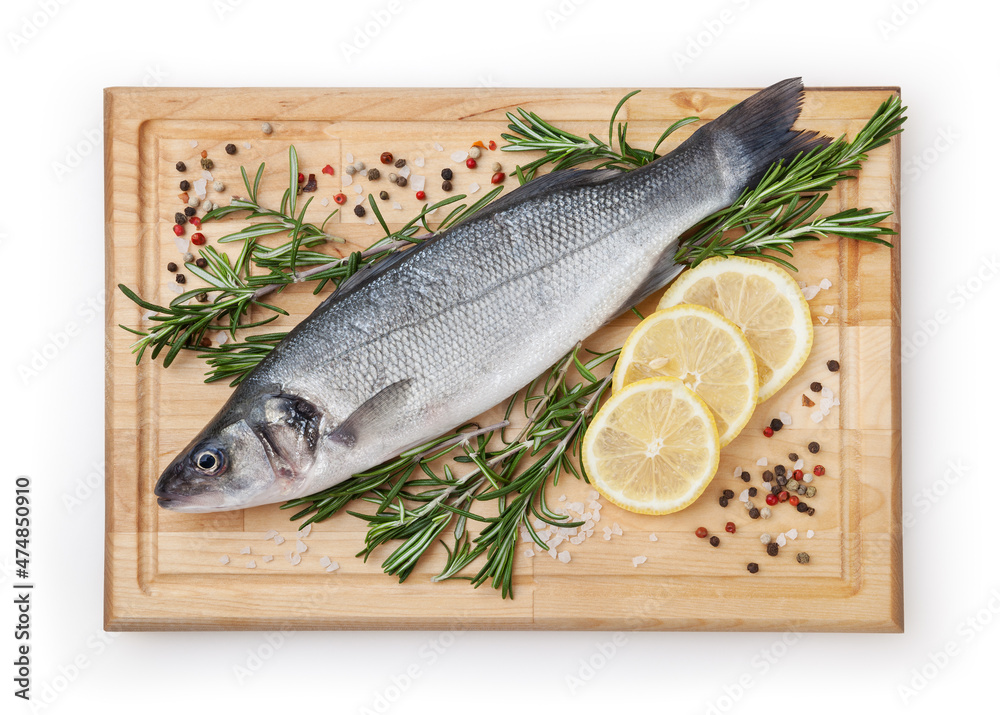 Fresh uncooked sea bass with lemon, rosemary and spice on wooden board isolated on white backdground with clipping path Fresh uncooked sea bass with lemon, rosemary and spice on wooden board isolated on white backdground with clipping path