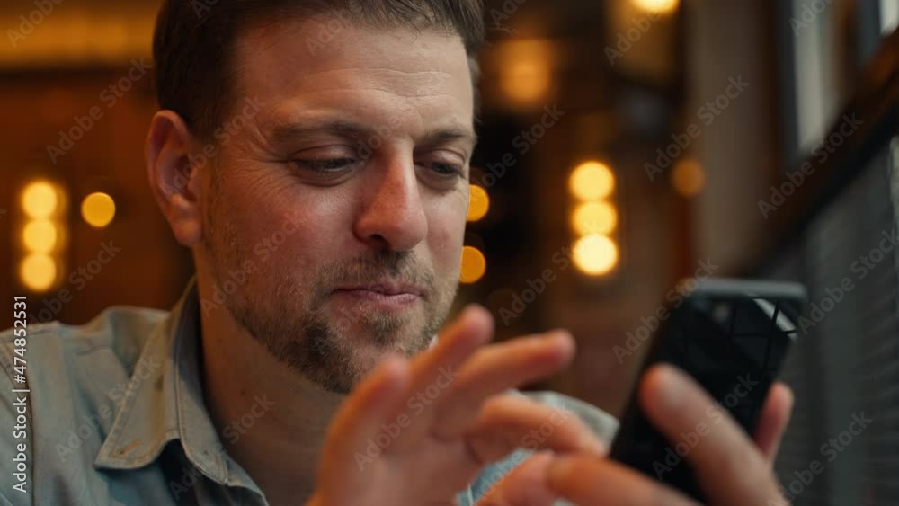 Close up of happy middle-aged beard man holding a cellphone to send a message in cafe businessman using mobile phone in hotel people lifestyles with mobile technology Close up of happy middle-aged beard man holding a cellphone to send a message in cafe businessman using mobile phone in hotel people lifestyles with mobile technology