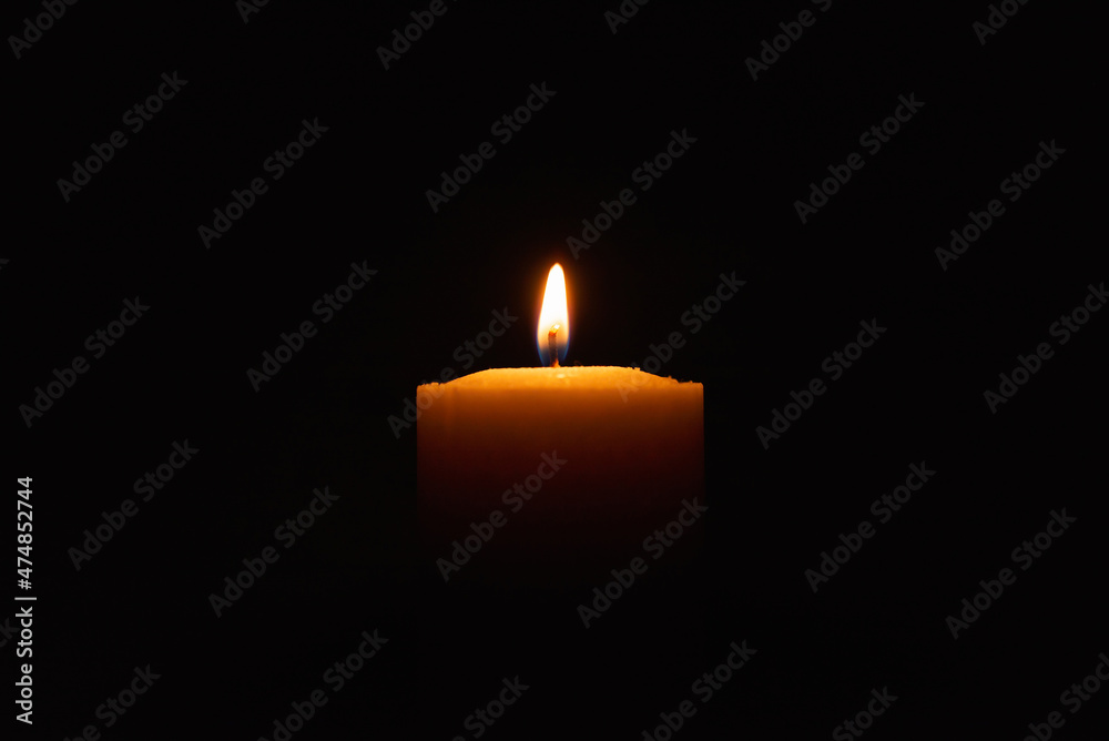 One single light candle burning brightly in the black background.Spiritual candle yellow flame. Flame of candle in the darkness.Copy space. One single light candle burning brightly in the black background.Spiritual candle yellow flame. Flame of candle in the darkness.Copy space.