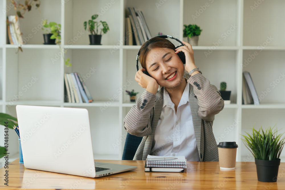 Asian businesswoman with headphones working on touchpad in the office. Asian businesswoman with headphones working on touchpad in the office.