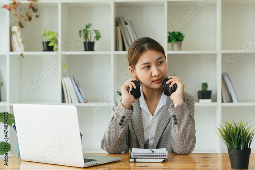 Young woman having online training, using laptop and wireless headset