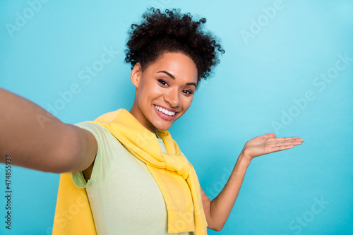 Photo of youth cheerful girl record video show hand emepty space promo advertise isolated over blue color background photo