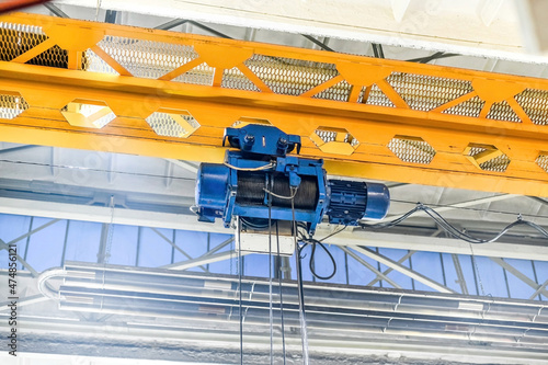 In the metalworking workshop there is a working electric drive of an overhead crane.