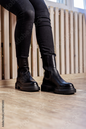 Female legs in black leather boots. New collection of winter boots for women